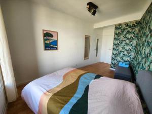 sypialnia z łóżkiem z kolorowym kocem w obiekcie Grande terrasse, vue mer w Marsylii
