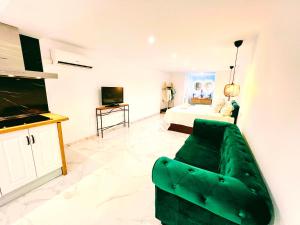 sala de estar con sofá verde y dormitorio en Garden Boutique, en Mijas Costa