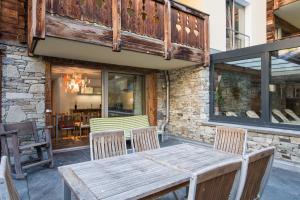a wooden table and chairs on a patio at Firefly Luxury Suites in Zermatt