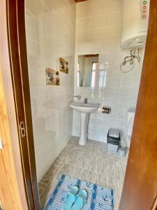 a bathroom with a sink and a toilet and a sink at Eram Garden Hotel in Bosteri