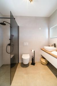 a bathroom with a shower and a toilet and a sink at Apartman A`Mare in Postira