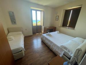 a room with two beds and a window at Hotel Villa Cerelis in Diamante