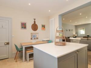 a kitchen and living room with a table and a couch at The Garden Flat in Bridport