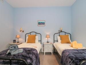 a twin bedroom with two beds and two lamps at The Garden Flat in Bridport