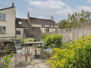 um pátio com cadeiras e uma mesa num jardim em Lavender Cottage em Lyme Regis