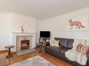 uma sala de estar com um sofá e uma lareira em White Horse Cottage em Weymouth