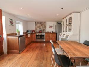 uma cozinha com uma mesa de madeira e um piso de madeira em White Horse Cottage em Weymouth