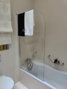 een badkamer met een douche met een glazen achterdeur bij Luxury Seaview Mellieha Apartment in Mellieħa