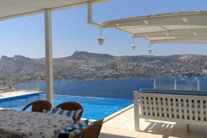 a patio with a table and chairs and a view of the water at MAGNIFICENT VIEW with Private Pool & Piano, 3 Bedroom Villa, MIN 4 nigths in Gundogan