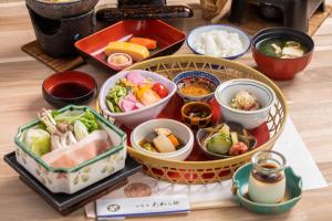 un grupo de tazones de comida sobre una mesa en Shirasagiyu Tawaraya, en Kaga