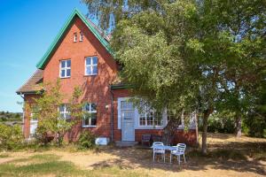 a brick house with a table and chairs in front of it at Alter Bahnhof Bresewitz in Bresewitz