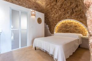 una camera da letto con un grande muro in pietra e un letto di Federico Holidays - Bed & Breakfast con piscina a Racale