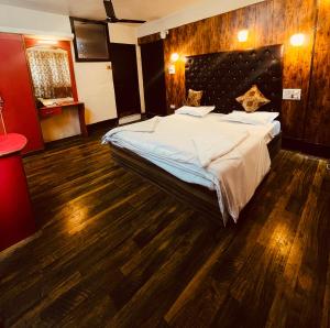 a bedroom with a large bed and a wooden floor at Hotel Royal inn and restaurant in Srinagar