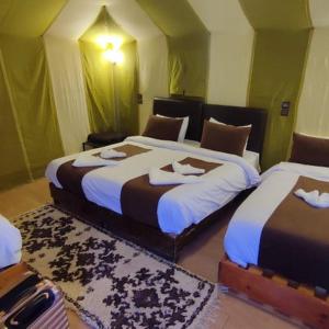 a bedroom with two beds with towels on them at Magic Luxury Camp in Merzouga