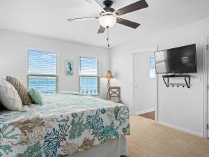 a bedroom with a bed and a flat screen tv at Bay Breeze Bungalow in Rockport