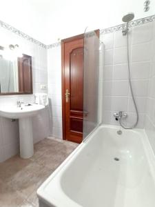 uma casa de banho com uma banheira, um lavatório e um chuveiro em Apartamento calle Real em Cambados