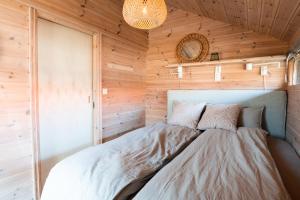 ein Schlafzimmer mit einem Bett in einer Holzwand in der Unterkunft Jølstraholmen Camping og Hytter in Vassenden