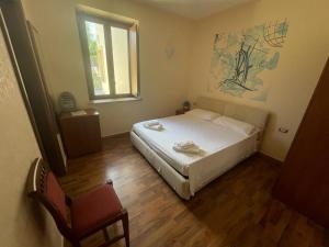 1 dormitorio con cama, ventana y silla en Hotel Villa Cerelis, en Diamante