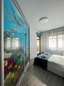 sypialnia z dużym obrazem na ścianie w obiekcie Pina Colada - Neptun Park by OneApartments w Gdańsku