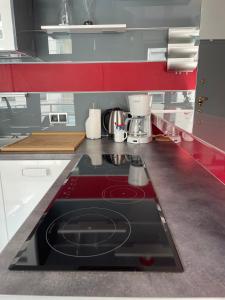 kuchnia z czerwoną płytą kuchenną w kuchni w obiekcie Pina Colada - Neptun Park by OneApartments w Gdańsku