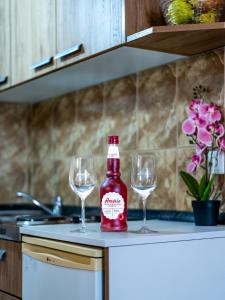 una bottiglia e due bicchieri di vino su un bancone della cucina di Apartmani VINKO Bibinje a Bibinje (Bibigne)