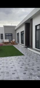 a house with a patio and a green lawn at شاليهات أبيات الفندقية in Al Baha