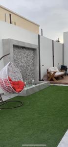 una sala de estar con una hamaca en una alfombra verde en شاليهات أبيات الفندقية en Al Baha