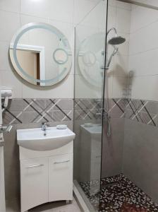 bagno con doccia, lavandino e specchio di Navodari Luxury Apartament a Năvodari