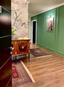 a living room with green walls and a wooden floor at NOVI's Luxury Apartment 2 in Gjirokastër