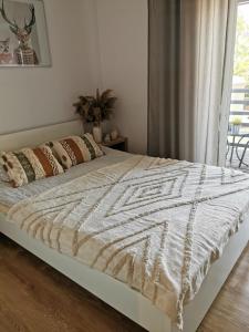 Una cama con un edredón blanco en un dormitorio en Kamienica, en Uniejów