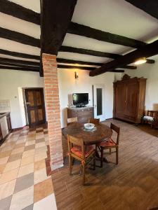 una sala de estar con una mesa y un pilar de ladrillo en Borgo Antico di Masserano tra laghi e monti en Masserano