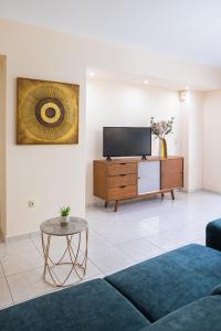 a living room with a tv and a couch and a table at Niovi Luxury Apartment in Samos
