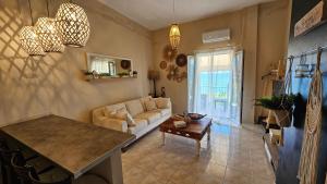 ein Wohnzimmer mit einer Couch und einem Tisch in der Unterkunft BeachHouse in Arkondikó