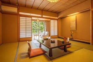 a living room with a table and chairs at Shirasagiyu Tawaraya in Kaga