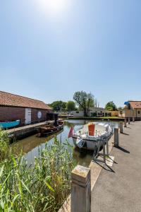 a small boat is docked next to a dock at Broads Reach - Norfolk Holiday Properties in Stalham