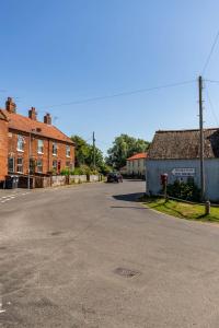 an empty street in a town with brick buildings at Broads Reach - Norfolk Holiday Properties in Stalham