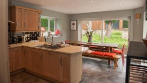 a kitchen with wooden cabinets and a table with a bench at Brooklands in Lyme Regis
