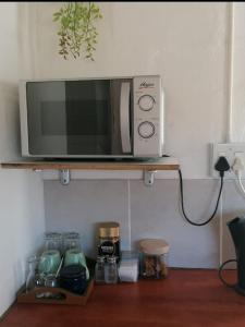 a microwave sitting on top of a shelf at Hoenerhok in Vanrhynsdorp