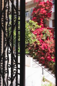 un balcone con fiori rossi di fronte a un edificio di Bugan-Villa ad Atene