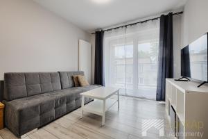 a living room with a couch and a table at Primo V by LookAp in Łódź