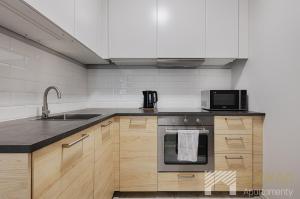 a kitchen with a sink and a microwave at Primo V by LookAp in Łódź
