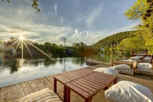 a wooden dock with a table and chairs next to a lake at Agva Greenline Guesthouse (Adult Only +12) in Agva