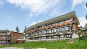a building on top of a grassy hill at V du Bachat Droseras 16 - Appt 4-5 pers in Chamrousse