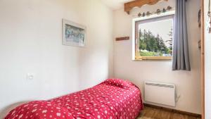 a bedroom with a red bed and a window at V du Bachat Droseras 16 - Appt 4-5 pers in Chamrousse