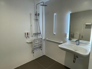een witte badkamer met een wastafel en een spiegel bij Hotel C31 in Castelldefels