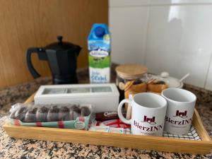 una bandeja con tazas de café y donuts en una barra en BierzINN apartamento, en Ponferrada