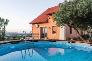a swimming pool in front of a house at Myron Olive Villa Retreat in Áyios Míron