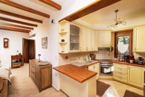 a kitchen with white cabinets and a wooden counter top at Myron Olive Villa Retreat in Áyios Míron