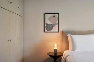 a bedroom with a bed and a table with a candle at Chic designer home next - Hilton in Athens