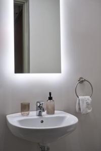 a white sink in a bathroom with a mirror at Chic designer home next - Hilton in Athens
